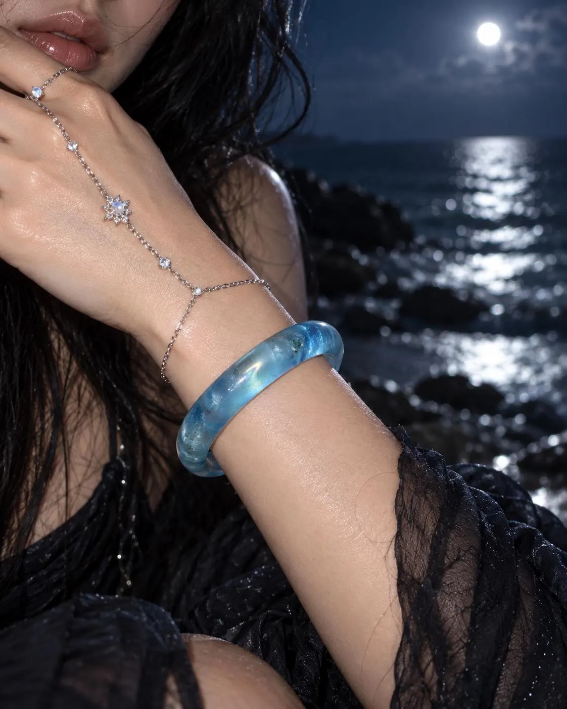 The same blue bangle worn on a wrist at night by the sea, a shot made in Higgsfield from the real photos.