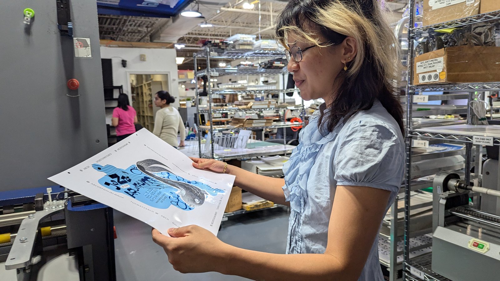 Danielle checking a printed sheet of her Jazz at the Aquarium magnet