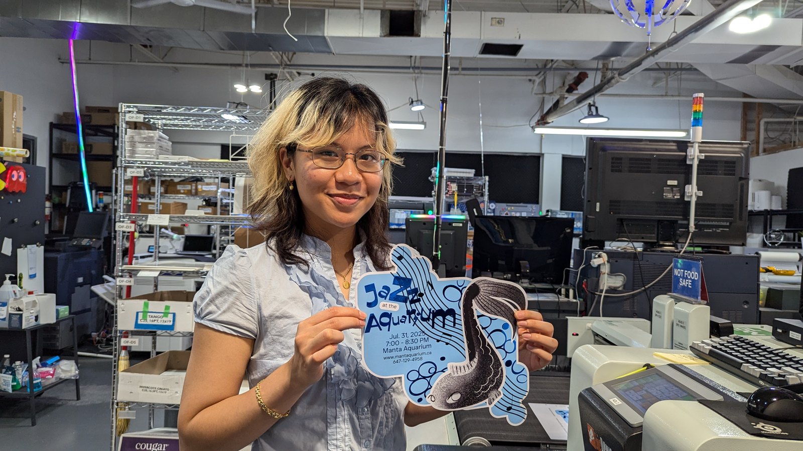 Danielle holding the finished die cut Jazz at the Aquarium magnet