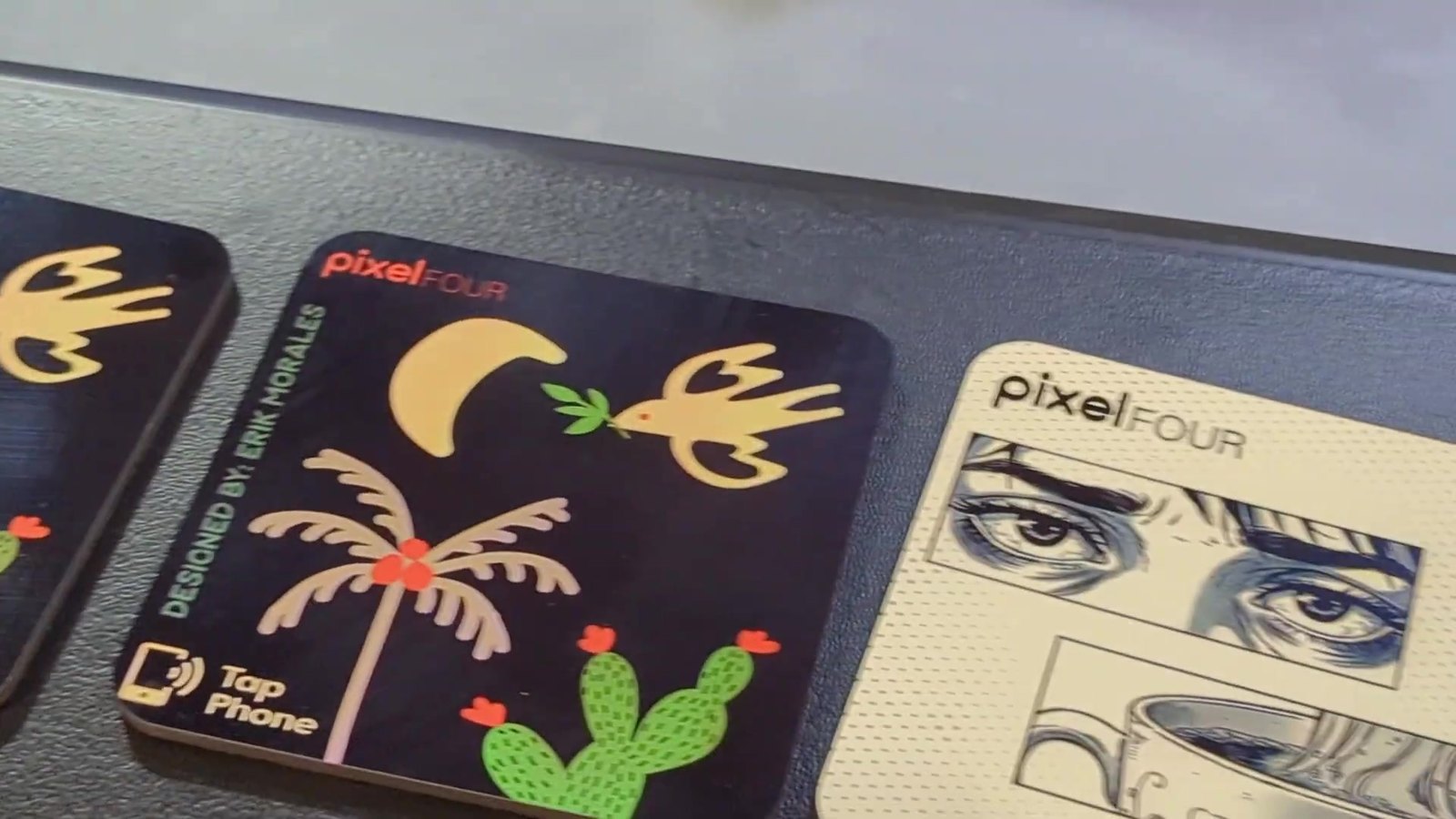 Erik’s pixelFOUR coaster with a palm tree, cactus, moon and bird, credited Designed by Erik Morales, with a tap to phone icon