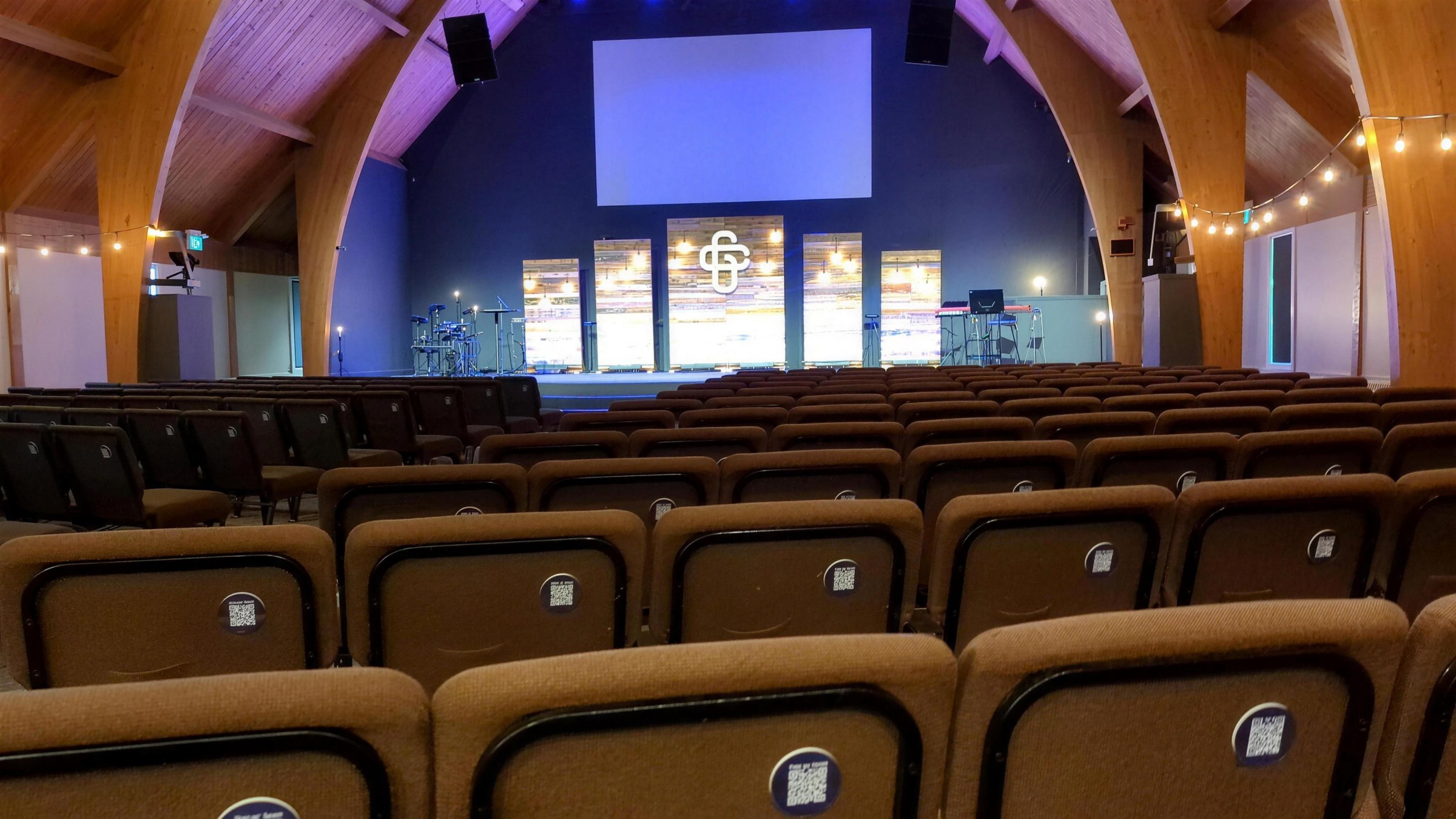Rows of church chairs, each with a Tap or Scan plaque on the back