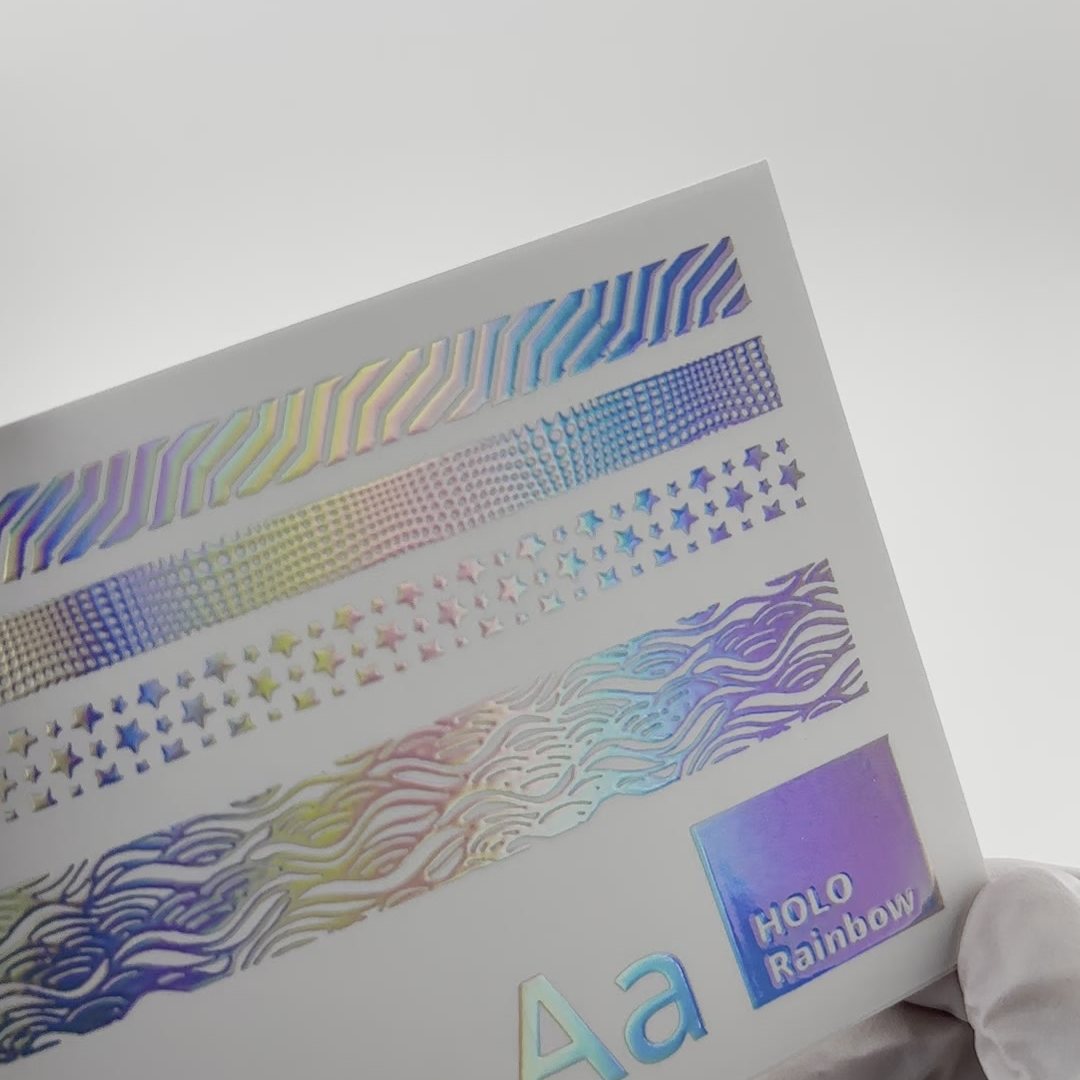 Foil swatch card in holo rainbow foil, showing wave lines, dot gradients, stars and type at several sizes