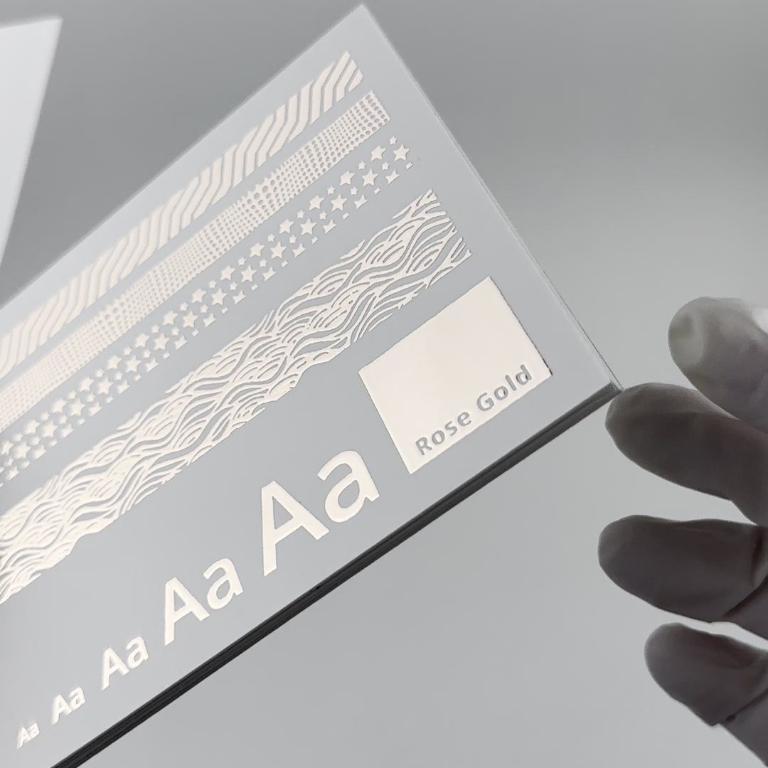 Foil swatch card in rose gold foil, held in a gloved hand
