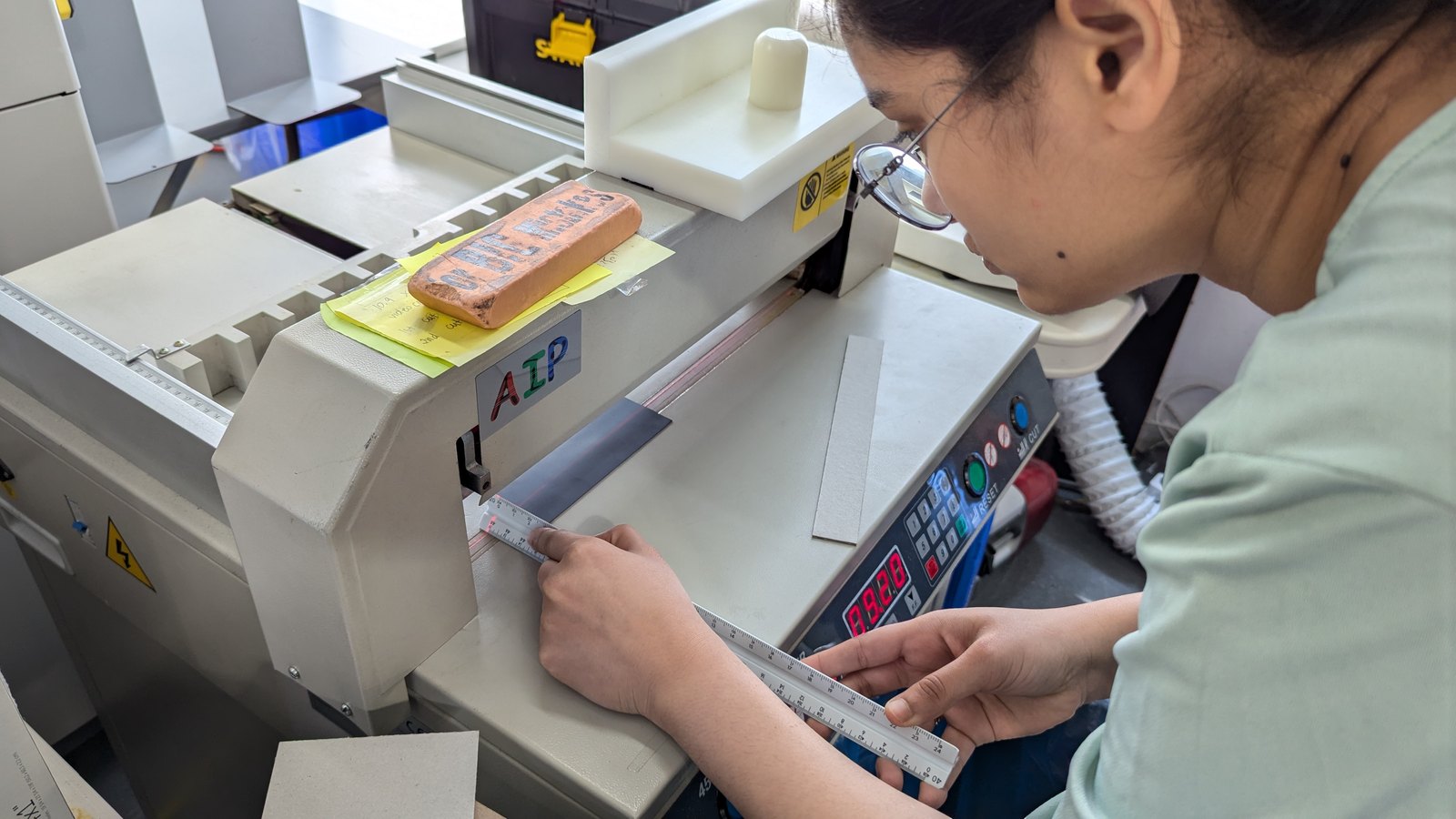Sana measuring a board at the cutter