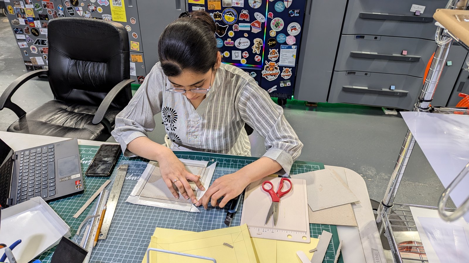 Sana assembling a box prototype on a cutting mat