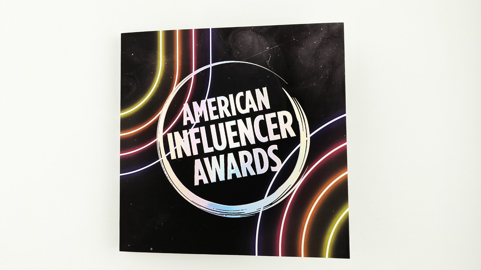 Cover of the American Influencer Awards video card, with the logo in holographic foil