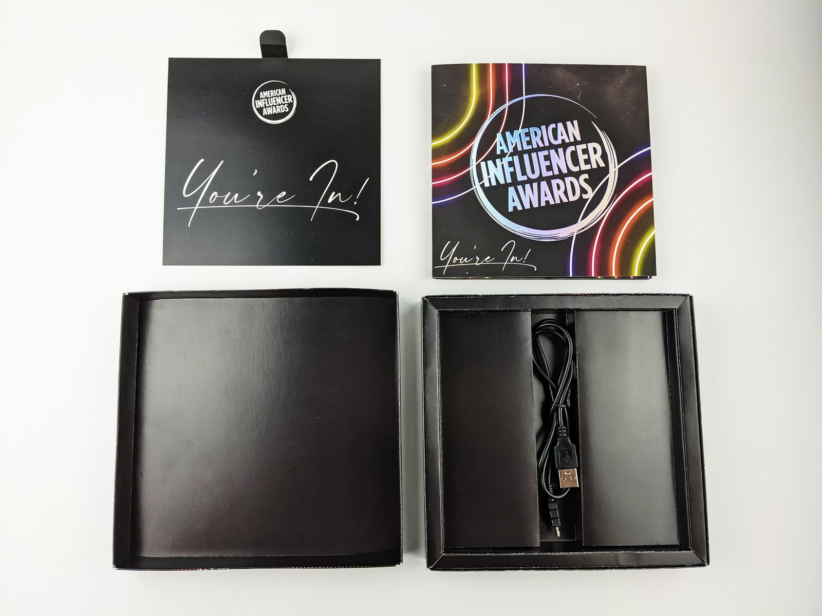 The pull up insert and the video card set beside the tray, showing the charging cable held in its own die cut slot